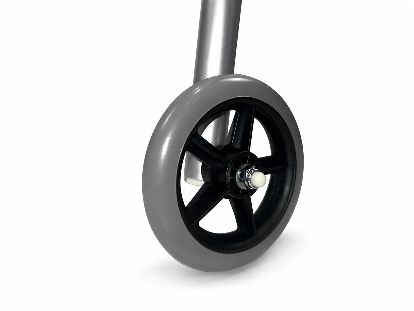 Close-up of the walking frame's grey 5-inch front wheel at the base of the silver aluminium leg.