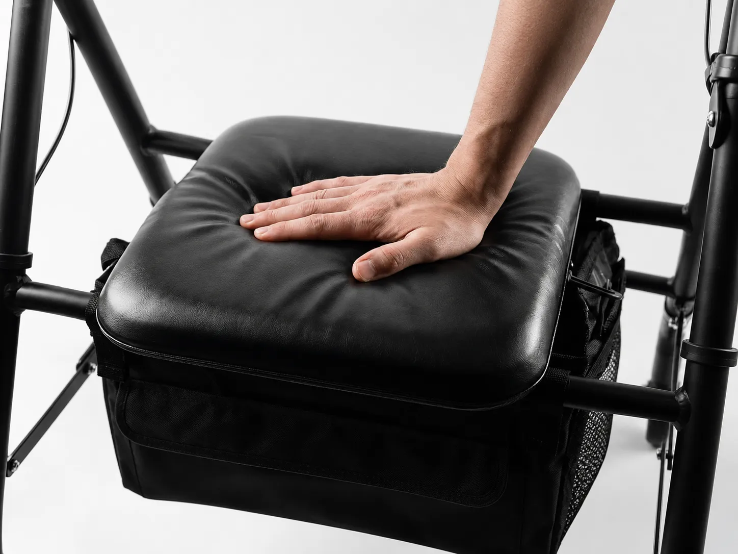 Close-up of the EazyFold rollator's soft padded seat and removable under-seat storage bag with mesh pockets.