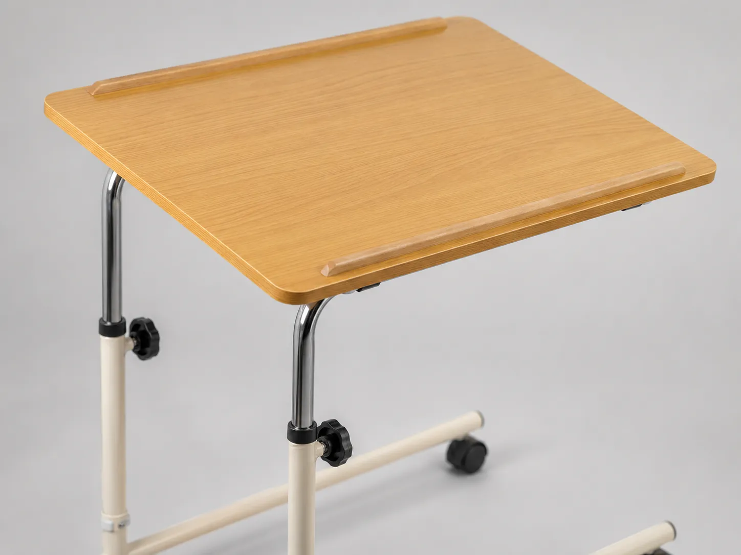 Close-up of the Eazy Glide overbed table's smooth beech laminate top and reinforced steel frame.