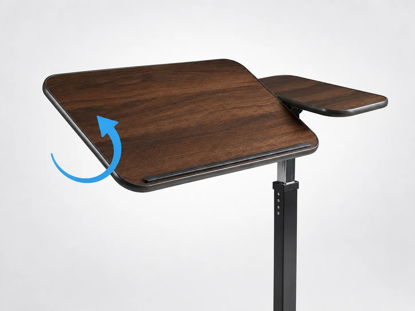 The U-Base table's main walnut section tilted to a reading angle while the smaller side section stays level, with a raised edge on the tilting section.